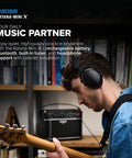 Person playing guitar with Katana-Mini X 10-Watt Mini Amp For Electric, Acoustic And Bass With Tube Logic Design in background.