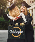 Graduates hugging with a "Happy Graduation" gift bag held in hand, showcasing Two Pack 13 Inch Graduation Gift Bags With Tissue Paper Reusable Nonwoven Gift Bags With Handles 12.8 X 10.2 X 6.3 Inch Size Perfect For Grads Class Of 2026 College High School Or 8th Grade Graduation Includes Wrapping Paper Greeting Cards And Stickers.