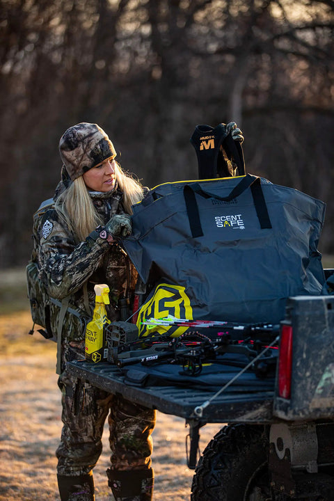 Hunter using Scent Safe Deluxe Travel Scent Bag For Hunting Gear And Clothing over truck bed outdoors