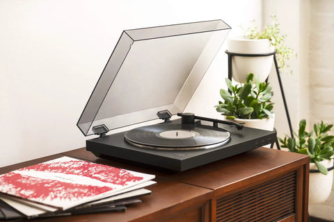 Sony PS-LX310BT Belt Drive Turntable Fully Automatic Wireless Vinyl Record Player with Bluetooth Connectivity USB Output Two Speeds 33 And 45 RPM Easy One Step Operation Built In Phono Preamp For High Quality Audio Playback on wooden table with vinyl records.