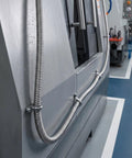 Heavy Duty Stainless Steel Bendable Conduit Sleeve for Weatherproof Cable Management and Secure Wire Protection in Garage or Shop, mounted along machinery.