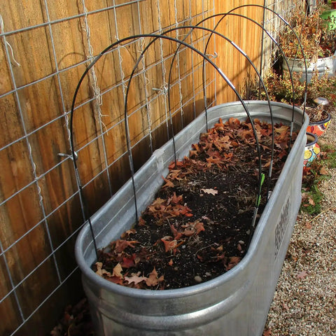 Image showing All Purpose Garden Hoop Kit With 5 Sets Of 7 Foot Fiberglass Hoops For Raised Beds Rust Proof Frame with leaves inside bin.