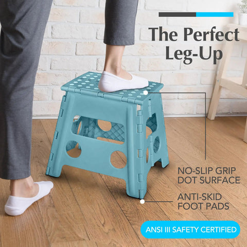 Person stepping on teal 13-inch foldable step stool with 300 lb capacity in home setting, featuring non-slip surface and anti-skid pads.