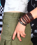 Dope Vintage Punk Wrap Bracelet Set Of Six Braided Faux Leather Cuffs For Men And Women shown stacked on a wrist with green cargo shorts.