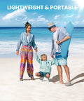 Family on the beach with dad carrying a Pop Up Beach Tent For 3 To 4 People With Sandbags, Easy One Person Setup, Portable Sun Shade Canopy