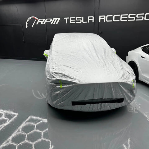 Badass Heavy Duty Weatherproof Car Cover For Tesla Model X silver microfiber cover fitting snugly over the vehicle inside a garage.