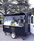 Hustle Ready Mobile Catering Trailer With Full Cooking Line And Spacious Serve Window, black fiberglass design for outdoor events.