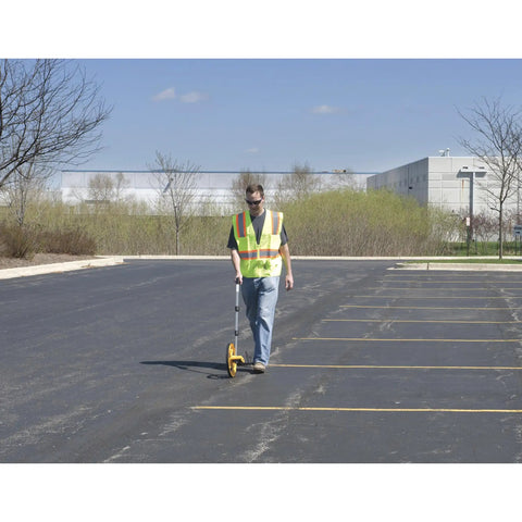 Contractor using measuring wheel with 3 foot circumference, 5 digit counter, and orange wheel in parking lot
