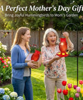 Two women in garden with red glass pineapple hummingbird feeder, 2-pack, 16 oz. Perfect Mother's Day gift idea.