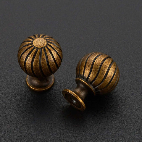 Antique Brass Cabinet Knobs Set, 12 Pack, 1 Inch Round Dresser Drawer Knobs With Raised Fluted Groove on black surface
