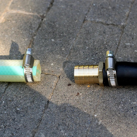 Solid Brass Garden Hose Repair Kit With Three Quarter Inch Barb Fittings And Six Stainless Clamps on concrete surface