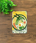Vintage Ramen Tin Sign Metal Wall Art 8x12 Inch Aluminum Poster For Home Office Garage Decor With Pre Drilled Holes Easy To Mount Rustic Retro Kitchen Bar Sign on wooden surface with chopsticks and leafy greens design.