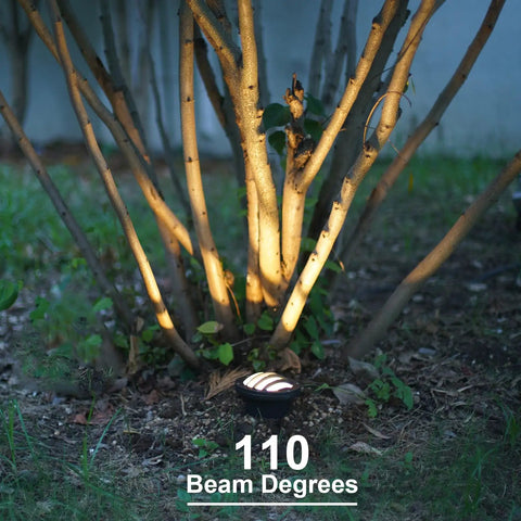Low Voltage LED Well Lights illuminating garden tree with 110 beam degrees, featuring brown aluminum housing.