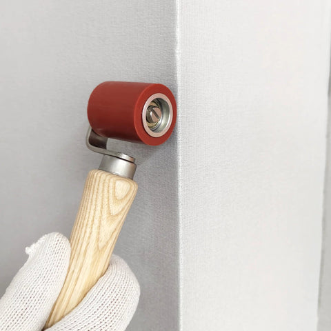Side view of handheld 40mm red silicone seam roller with wooden handle for wallpaper roofing tape