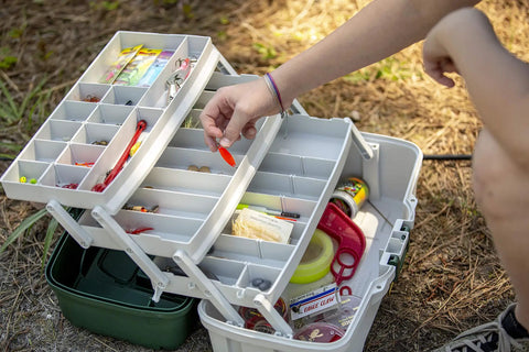 Angler organizing gear in a 3-Tray Tackle Box With Dual Top Access Dark Green Metallic And Off White Premium Tackle Storage outdoors.