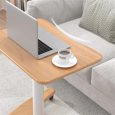 Real Slick Mobile Adjustable Standing Desk With Buttery Smooth Rollaway Casters, Ergonomic Height Adjusting Computer Cart and Cozy Bedroom Side Table For Zero Fuss Home Office Flow, Straight Up Game Changer on wooden surface with laptop and coffee cup.
