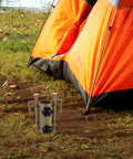 Orange tent with Six Pack Adjustable Camping Tent Poles And Stakes Kit with aluminum pegs on grassy outdoor setting.