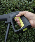 Close-up of a hand gripping the handle of a Powerful 12 Amp Electric Pressure Washer With Adjustable Spray Wand For Home Cleaning.