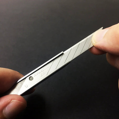 Close-up of hand snapping blade of ABS Grip 30-Degree Multi-Blade Cartridge Knife, 9mm Snap-Off Utility Knife, showing blade detail.