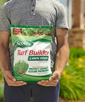 Person holding a bag of Scotts Turf Builder lawn food in a garden setting, promoting protection against future problems.