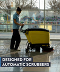 Woman operating a yellow automatic scrubber on glossy floors using Kick Ass Heavy Duty Low Foam Auto Floor Cleaner Industrial Strength Concentrate Deep Cleaning Solution Works Hard On Grease And Dirt On Concrete Floors No Streaks Or Residue Quick Dilution For Commercial Scrubbers.