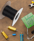 Flame Retardant Braided Cable Sleeve Expandable Mesh Wire Loom Cord Protector next to a spool of black wire and circuit board.