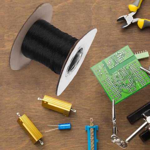 Flame Retardant Braided Cable Sleeve Expandable Mesh Wire Loom Cord Protector next to a spool of black wire and circuit board.