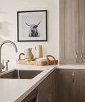 Precept Single Handle Kitchen Faucet With Side Sprayer In Stainless installed on white countertop in modern kitchen
