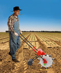 Farmer using Hand Push Seeder With Ten Nozzles For Garden Row Crops, Precision Seed Drill Planter, in a large field