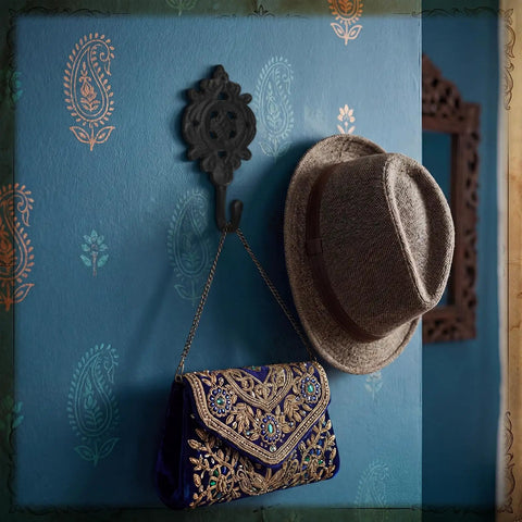 Six Pack Rock Solid Cast Iron Wall Hooks With Rustic Indian Leaf Design Heavy Duty Matte Black Finish holding a hat and embellished bag.