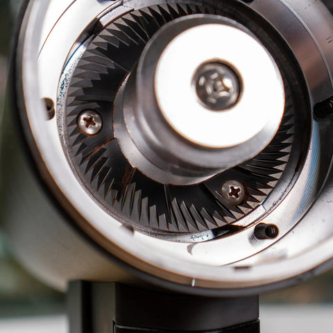Close-up of 83mm red titanium flat burrs inside Killer Variable Speed Single Dose Coffee Grinder for smooth espresso pulls.