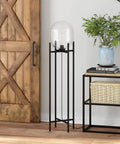 Tall Floor Lamp With Glass Shade In Blackened Bronze And Clear Finish, 55 Inch, placed next to a wooden cabinet and shelves