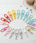 36 Pcs Colorful Swivel Snap Hooks Lobster Claw Clasps For Diy Crafts Jewelry Making Bag Charms in assorted colors on a wooden surface.