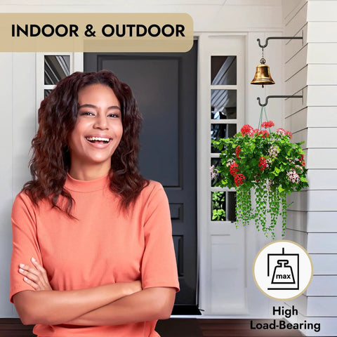 Outdoor view with heavy duty wrought iron plant hanger set of two for indoor or outdoor use, holding plants and a bell, classic black style.