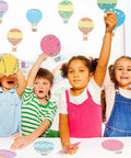 Children using Colorful Fun Hot Air Balloon Cutouts Set Of 45 5 By 7 Inch Classroom Bulletin Board Accents for activities.