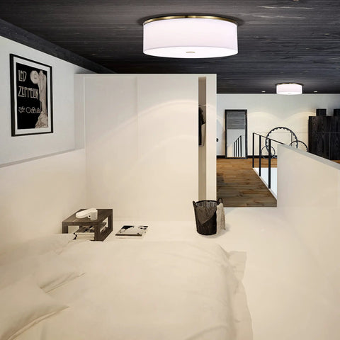 Antique Brass Drum Linen Flush Mount Ceiling Light, 20 Inch LED Fixture, illuminated in modern bedroom with white walls.