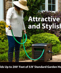 Person using Beefy 200 Foot Hose Storage Box With Internal Poly-Resin Reel, bronze finish, in garden with green hose