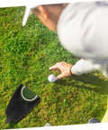 Person setting up Automatic Golf Putting Cup Return System Easy To Use Putting Trainer For Practice on a grassy lawn