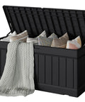 78 Gallon Waterproof Resin Deck Box With Lockable Bench open showing cushions and blanket, durable black resin with rattan pattern