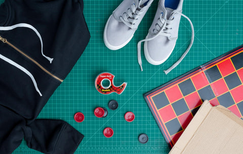 Super Hold Tape With 50 Percent More Adhesive, Clear Finish, 2 Rolls, Dispenser Ready, surrounded by games, shoes, and clothes on table