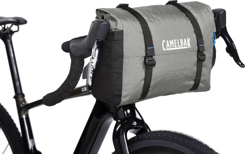 Mule 12 Bikepacking Waterproof Handlebar Bag With Roll-Top Design attached securely to a bicycle, showcasing its expandable capacity.