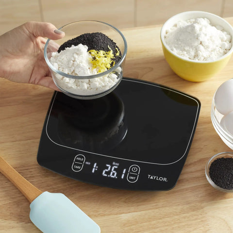 Waterproof Digital Kitchen Scale With 11 Pound Capacity Pro Grade Precision Ultra Accurate To 0.01 Oz And 1 Gram Tare Function Easy Clean Stainless Platform Ideal For Baking Cooking And Liquid Measurements on a countertop with ingredients.