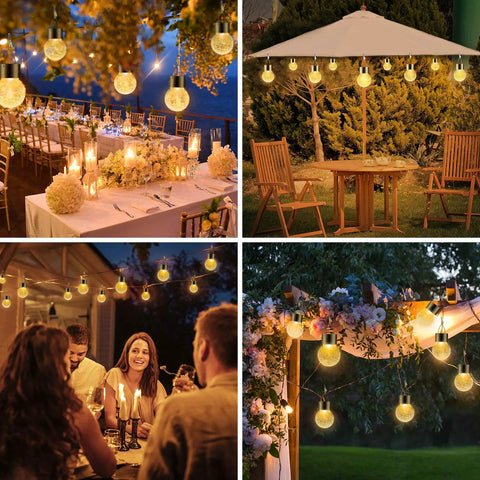 Solar Outdoor Lights Decorative 12 Pack Hanging Garden Lights Waterproof Solar Powered Globe Cracked Glass Ball Lanterns For Yard Patio Fence Tree Umbrella Holiday Decoration Warm White glowing at night in a garden setting with people dining.