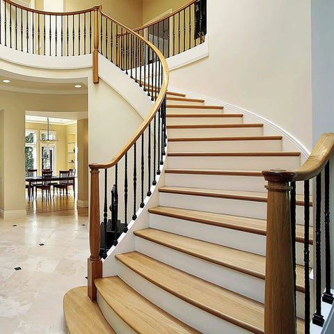 Indoor staircase with black iron baluster shoes for half-inch square balusters on curved railings, rust-resistant black finish
