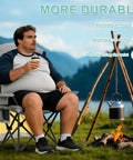 Man sitting on Two Pack Heavy Duty Folding Camping Chairs With 500 Pound Capacity by a campfire in a scenic outdoor setting