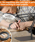 Man using 10X LED Desk Magnifier with Stand and Glass Lens for craft detail work on table.
