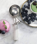 Thumb-Press Food Disher Ice Cream Scoop 4.67 Oz Size 6 White, 18/8 Stainless Steel, near bowls of ice cream and blueberries
