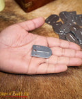 Hand holding a piece from 20 Piece Small Birka Lamellar Plates Gear Kit For Medieval Armor Made From Polished 20 Gauge Mild Steel