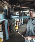 Mechanic wearing Dual Light Source USB Headlamp Twin Task 375 Lumen Hands Free Night Work Light With Tilt Head in garage.
