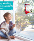 Window Hummingbird Feeder With Side Ports For Clear Viewing Big 20 Oz Nectar Capacity Durable Plastic Easy Clean And Refill Strong Suction Cups Outdoor Window Bird Feeder For Kids And Pets with child and pet watching hummingbirds.